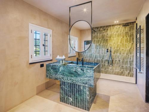 Villa Riviera Resort في لافانيا: حمام مع حوض ومرآة