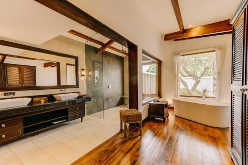 a large bathroom with a tub and a sink at Aditya Resort in Hikkaduwa