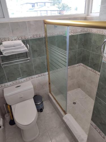 a bathroom with a toilet and a glass shower at Hotel Sumaq Kay in Cumbayá