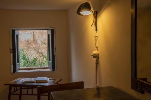 a lamp in a room with a table and a window at Hotel Signum in Malfa