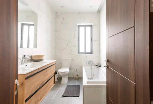 La salle de bains est pourvue de toilettes, d'un lavabo et d'une baignoire. dans l'établissement Stylish 3Bed Penthouse close to the Blue Grotto, à Żurrieq