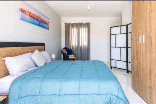 a bedroom with a blue bed and a chair at Stylish 3Bed Penthouse close to the Blue Grotto in Żurrieq