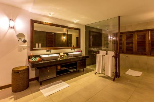 a bathroom with two sinks and a large mirror at Aditya Boutique Hotel in Hikkaduwa