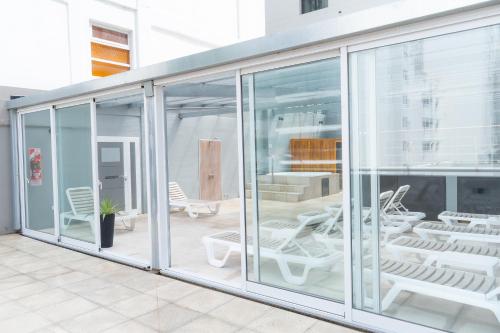 a room with glass doors and chairs on a balcony at Hotel Traful in Mar del Plata