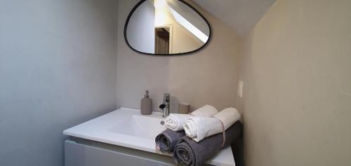 y baño con lavabo blanco y espejo. en L'Echappée Morétaine - Cœur de Moret, en Moret-sur-Loing