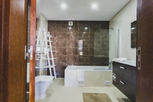 a bathroom with a toilet and a bath tub at Best Houses 03 - Deluxe Two Bedrooms and Pool - Design Apartment in Ferrel
