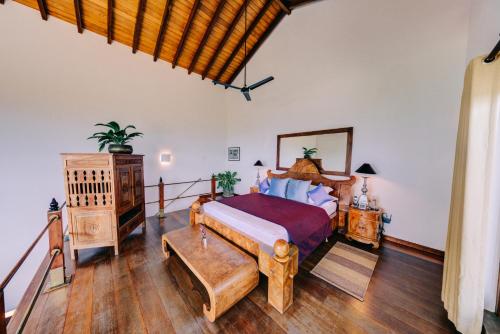 um quarto com uma cama grande e pisos em madeira em Aditya Resort em Hikkaduwa
