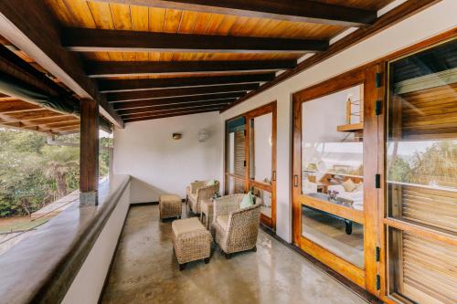 a living room with wooden ceilings and windows at Aditya Resort in Hikkaduwa