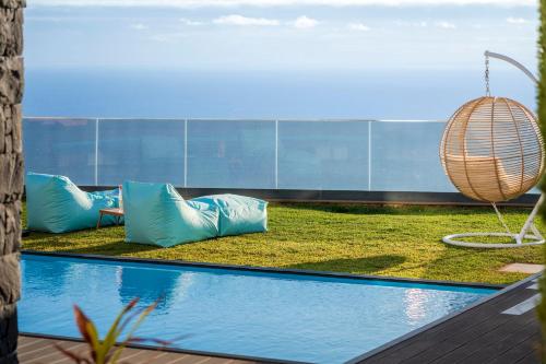 a swimming pool with blue pillows next to a building at Villa Candelária by An Island Apart in Ribeira Brava
