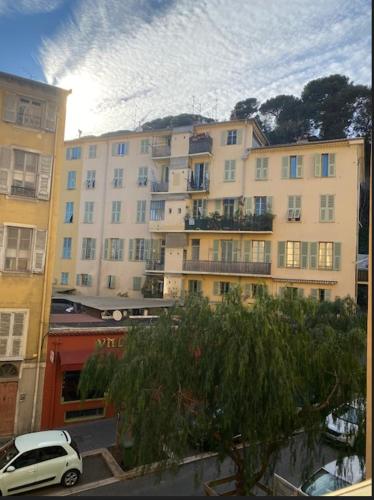 une voiture blanche garée devant un grand bâtiment dans l'établissement Studio Nice Le Palais, avec cuisine et espace repas séparés, dans immeuble niçois, Port de Nice, Vieux Nice, Place du pin et Garibaldi, Colline du château, à 2 minutes de la promenade des Anglais, à Nice