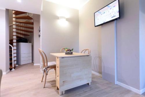 a dining room with a table and a tv on a wall at Agriturismo Tenuta "Il Cigno" in Villanterio