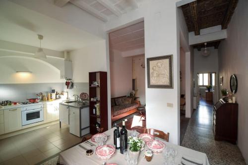 una cucina e un soggiorno con tavolo e bicchieri da vino di Cozy apartment with private garden - CITY CENTER - a Firenze