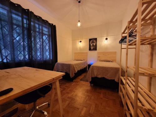 a room with two beds and a wooden floor at Quarto Black Power in São Paulo