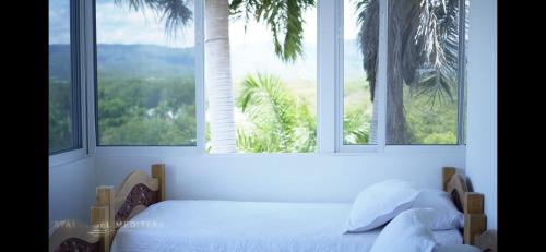 a bedroom with a bed in front of a window at Cristales del Mediterraneo in Girardot