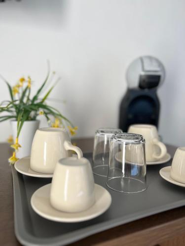 a tray with plates and glasses and a coffee maker at Bonadies64 B&B in Salerno