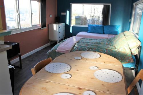 a room with a wooden table and a bed at Redwood Lodge, Dee Valley Stays - cosy microlodge with detached private shower & WC in Corwen
