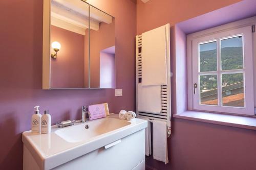 a bathroom with a white sink and a window at Isola Bella Apartments - Via Villa 28 in Stresa