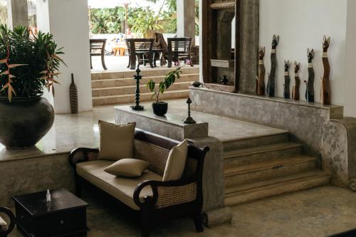 a living room with a couch and some stairs at Aditya Resort in Hikkaduwa