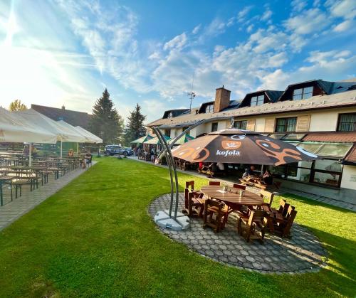 una mesa de picnic con una sombrilla junto a un edificio en Hotel STARÝ MLÝN en Jeseník