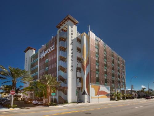 a large building on a city street with palm trees at The Marlin Beachside in Hollywood
