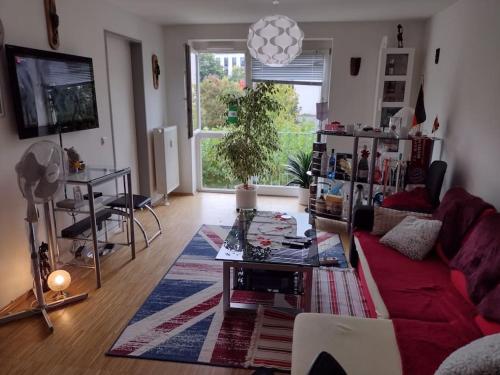 a living room with a red couch and a table at 1 apartment with 2rooms in München in Munich