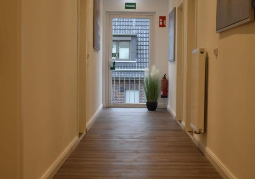 an empty hallway with a door and a potted plant at Hotel Sonnenschein - Spielerei im Sonnenschein in Dahme