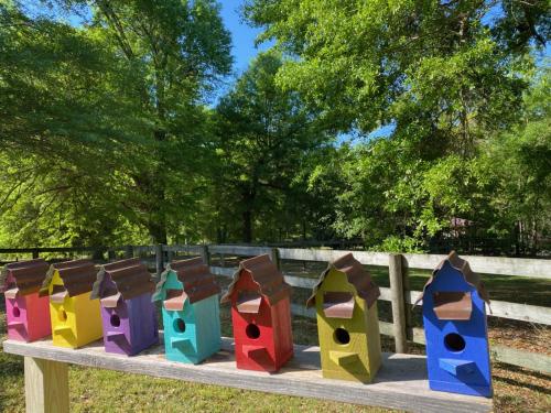 a row of colorful birdhouses on a wooden fence at The Birdnest Inn in Aiken