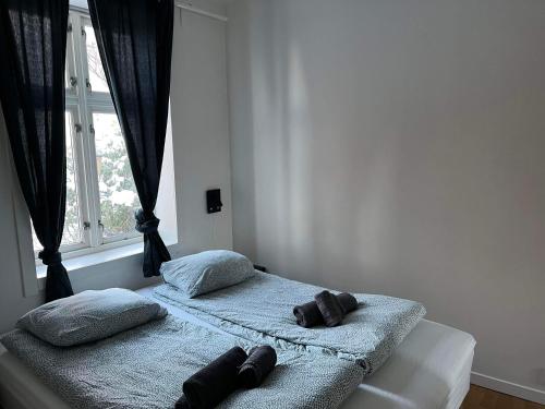um quarto com 2 camas com almofadas e uma janela em Fløyen Apartment em Bergen