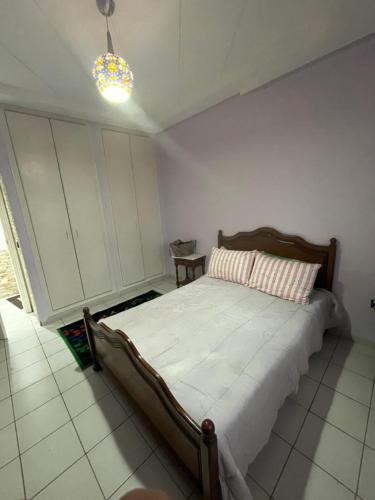 ein Schlafzimmer mit einem Bett in einem Zimmer in der Unterkunft Cité Jardin - Appartement Martil avec Climatisation in Martil