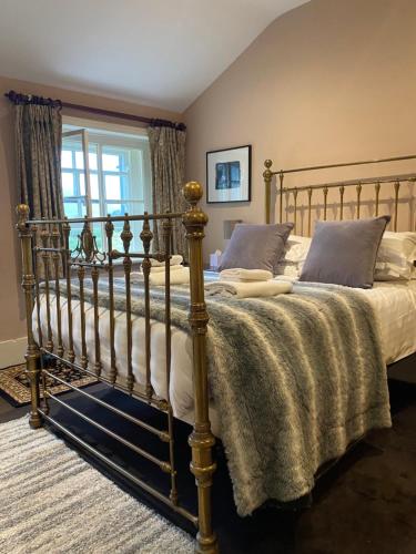 a bedroom with a metal bed with a blanket at The Derby Arms in Grange Over Sands