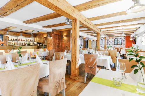 グダニスクにあるホテル グダニスク ブティックの白いテーブルと椅子、木製の天井が備わるレストラン