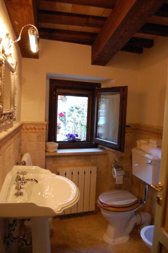 a bathroom with a toilet and a sink and a window at La Corte in Tolentino
