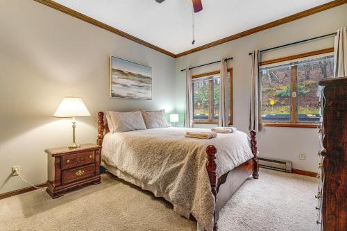 a bedroom with a bed and a lamp and windows at Skyleaf 703 in Sugar Mountain
