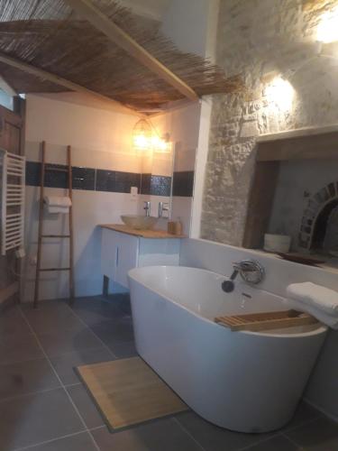 a large white bath tub in a bathroom at Au Domaine du Petit Cercoux in Saint-Saturnin-du-Bois
