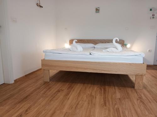 two white swans sitting on a bed in a room at Accommodation Baron in Ljubljana