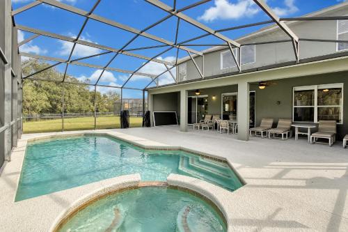 een binnenzwembad in een huis met een glazen plafond bij Mickeys Sunspot - 6 bed Emerald Island Resort pool home in Kissimmee