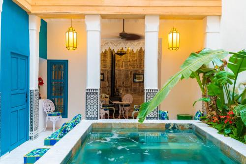 einen Innenpool in einem Haus mit blauen Akzenten in der Unterkunft Riad Tibibt in Marrakesch