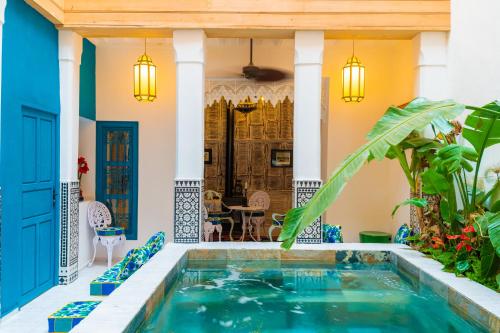 una piscina interna in una casa con accenti blu di Riad Tibibt a Marrakech