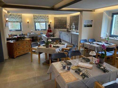 a restaurant with tables and chairs and a kitchen at Hotel Kreuzbergbaude beim Berzdorfer See in Görlitz