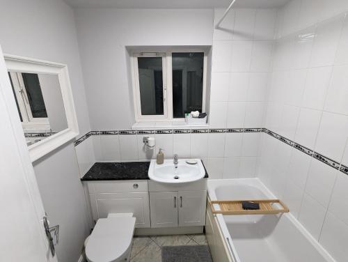 a white bathroom with a sink and a toilet at Greatmindz's home away from home in Bloxwich