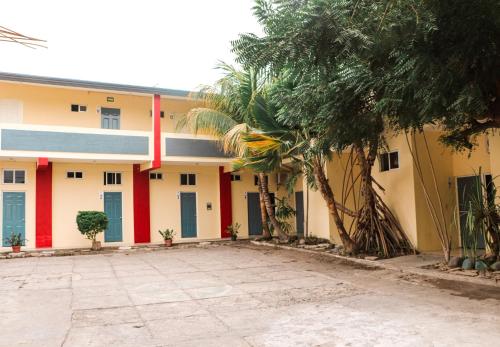 un edificio con una palmera delante de él en Hotel Pacific, en Tecomán