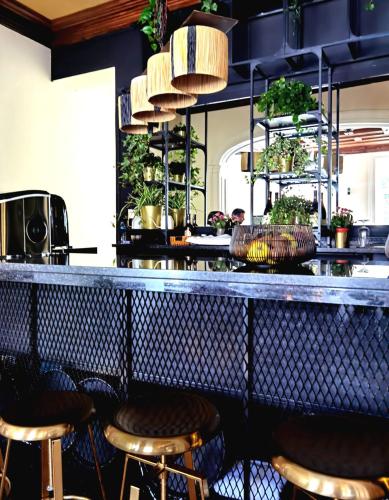 a bar with stools in a room with plants at Monsenhor52 in Porto