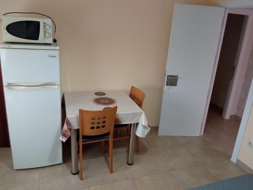 una pequeña cocina con mesa y nevera blanca en Bueu: studio Con vistas al mar- 1 room - 2 persons, en Bueu