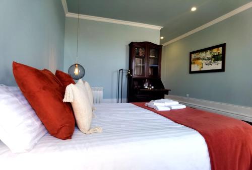 a bedroom with a large bed with red and white pillows at Monsenhor52 in Porto