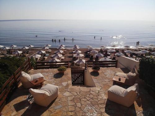 a group of chairs and umbrellas on a beach at Glorious Sunset & Sea View Studio Mariastella 5 in Agios Gordios