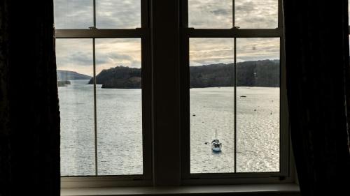 a window with a view of a boat in the water at Western Isles Hotel in Tobermory