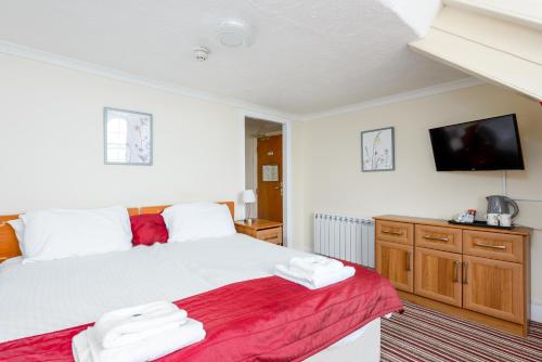 a bedroom with a bed and a flat screen tv at Hotel Prince Regent in Weymouth