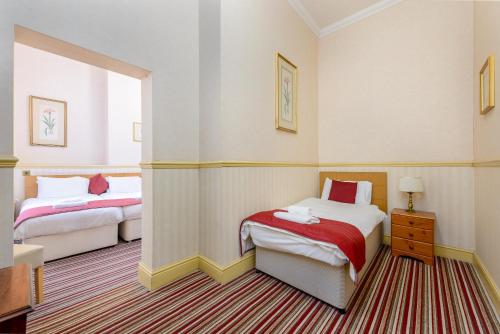 a hotel room with two beds and a room with two at Hotel Prince Regent in Weymouth