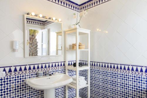 a bathroom with blue and white tiled walls and a sink at La Casa Del Puerto, Puerto Calero in Puerto Calero