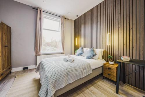 a bedroom with a large bed and a window at Modern apartment near Wembley Stadium in London